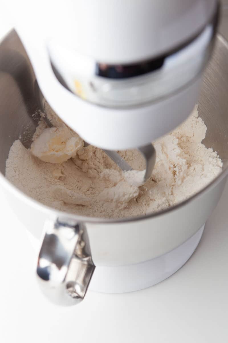 dry ingredients are being beaten together in a stand mixer