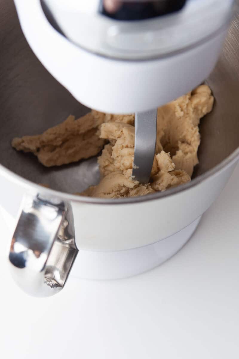 cookie dough is being mixed in a stand mixer
