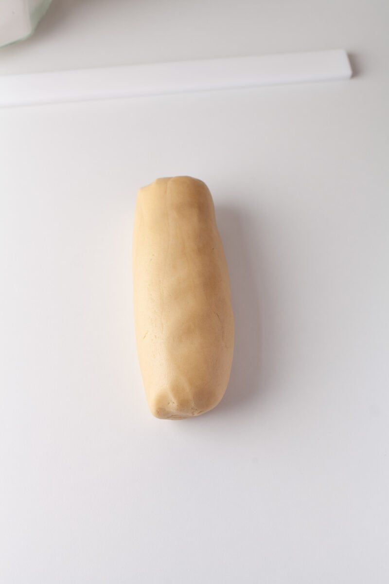 a log of cookie dough is placed on a white surface