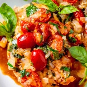 fresh grape tomatoes and basil and onions on top of chicken breasts