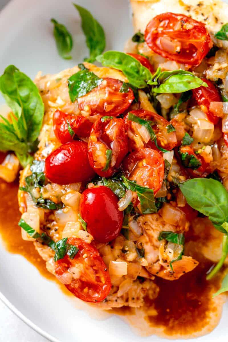 fresh grape tomatoes and basil and onions on top of chicken breasts