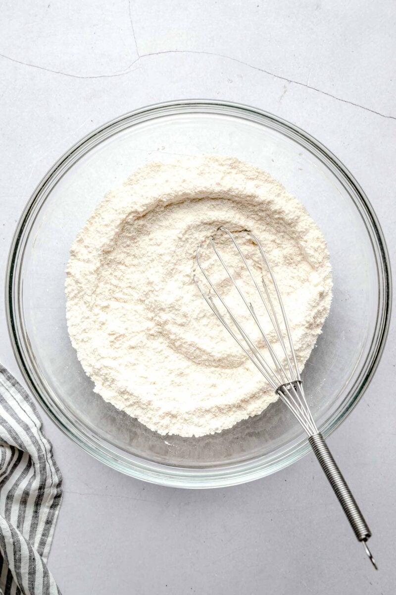 dry ingredients for lemon blueberry cupcakes with a whisk in a clear bowl