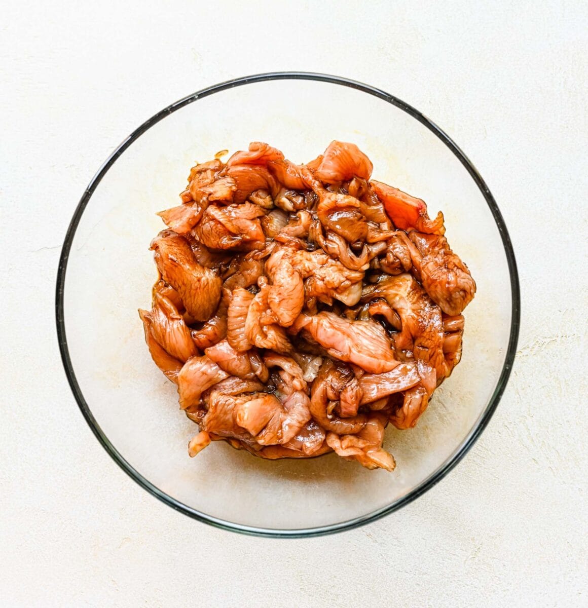 Marinating chicken in soy sauce in a bowl.