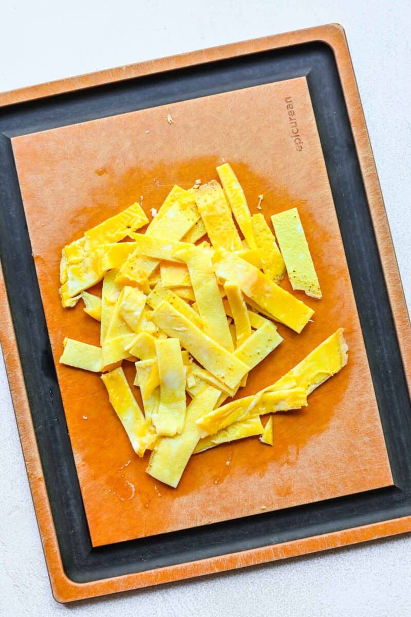 Cooked, sliced eggs on a cutting board.