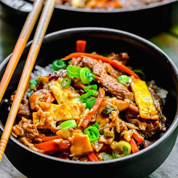 Moo shu pork served in bowls with chopsticks.