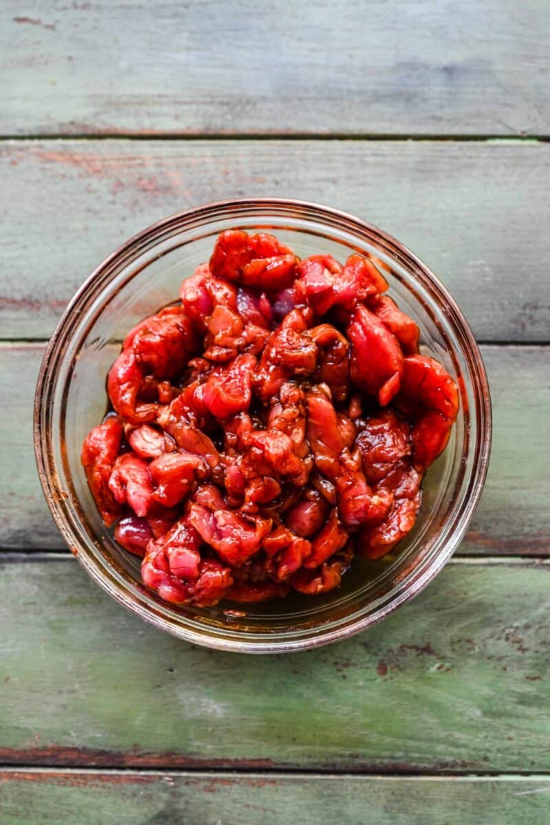 Marinading pork in soy sauce in a bowl.