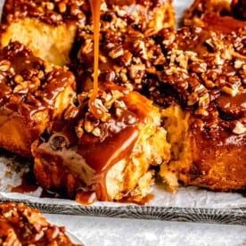 drizzling caramel on top of a sticky bun