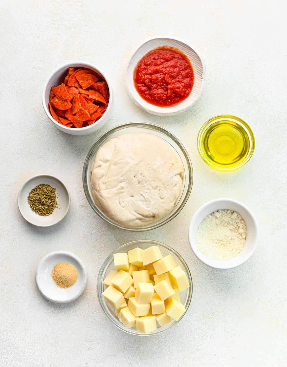 Ingredients for pizza bites separated into bowls.