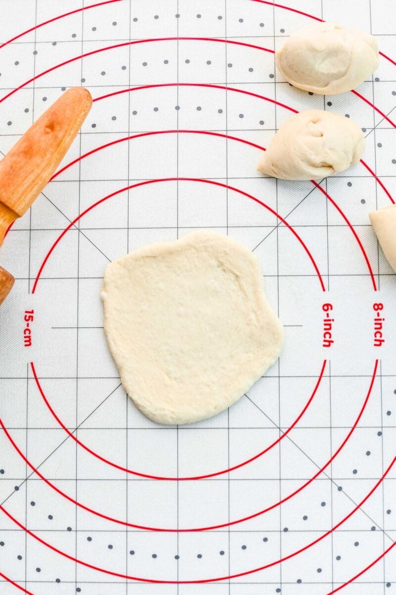 Rolling pizza dough into a circle.