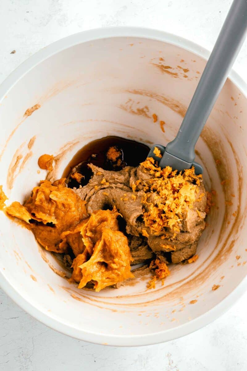 Wet ingredients for pumpkin oatmeal cookie dough being mixed in a white bowl.