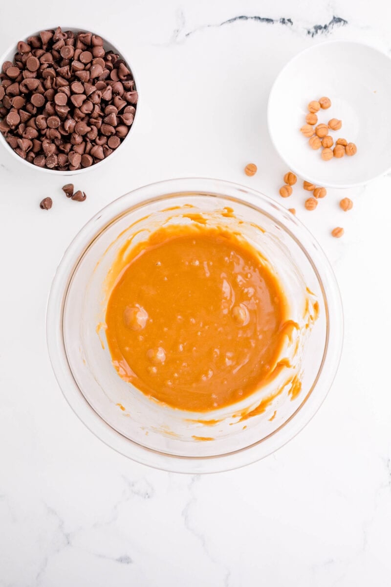 melted caramel is placed next to a bowl of chocolate chips