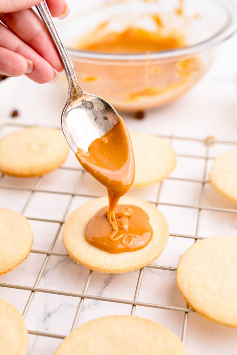 caramel is being drizzled onto a baked cookie