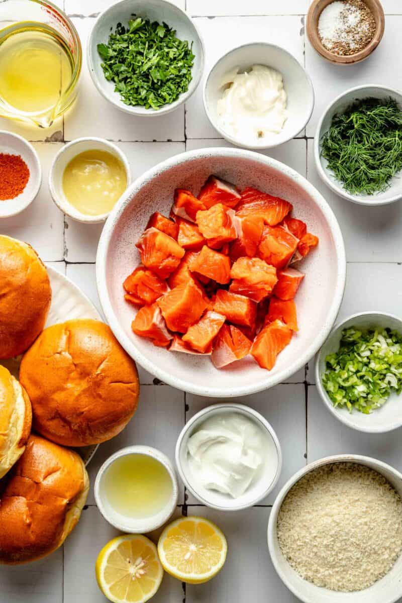 salmon burger ingredients are placed on a white surface