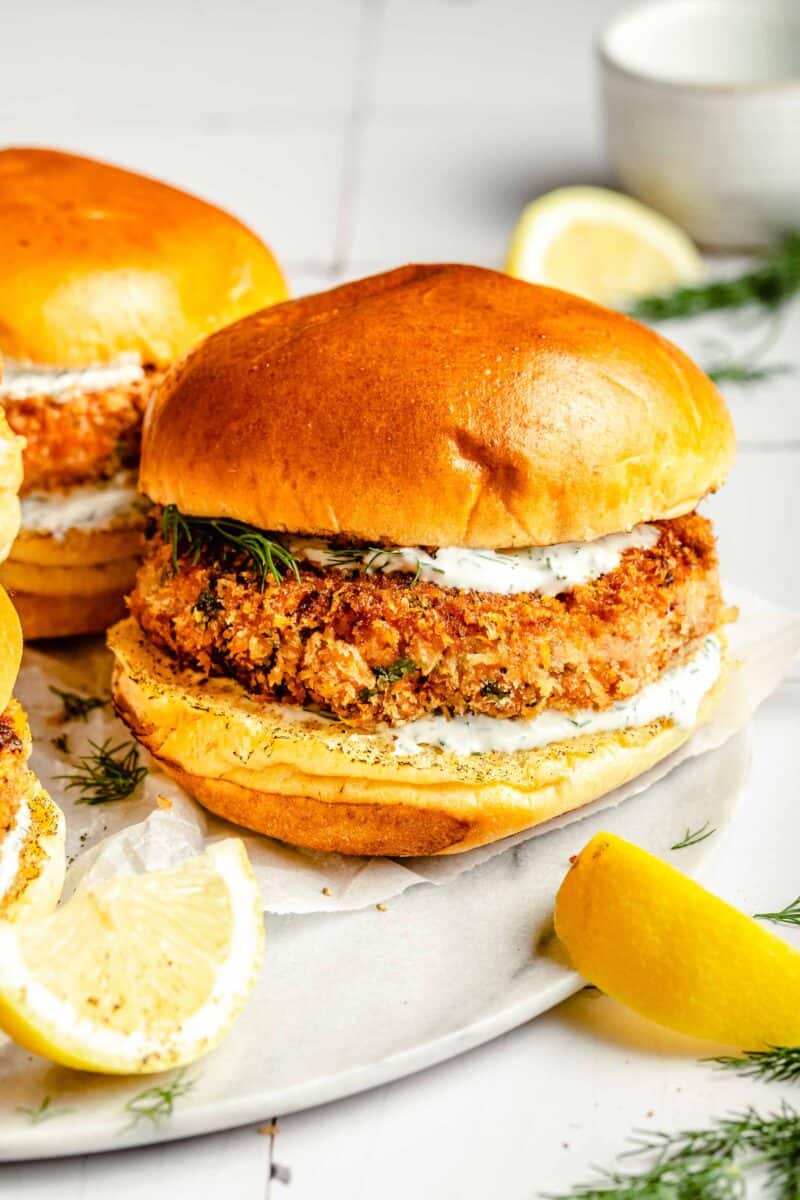 salmon burgers are placed next to lemon wedges