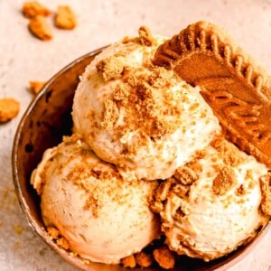 Scoops of Biscoff ice cream served in a bowl and topped with a Biscoff cookie.