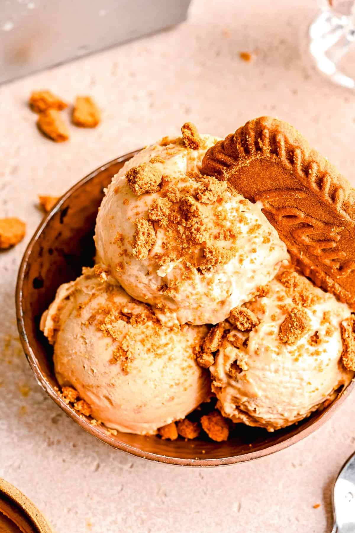 Scoops of Biscoff ice cream served in a bowl and topped with a Biscoff cookie.