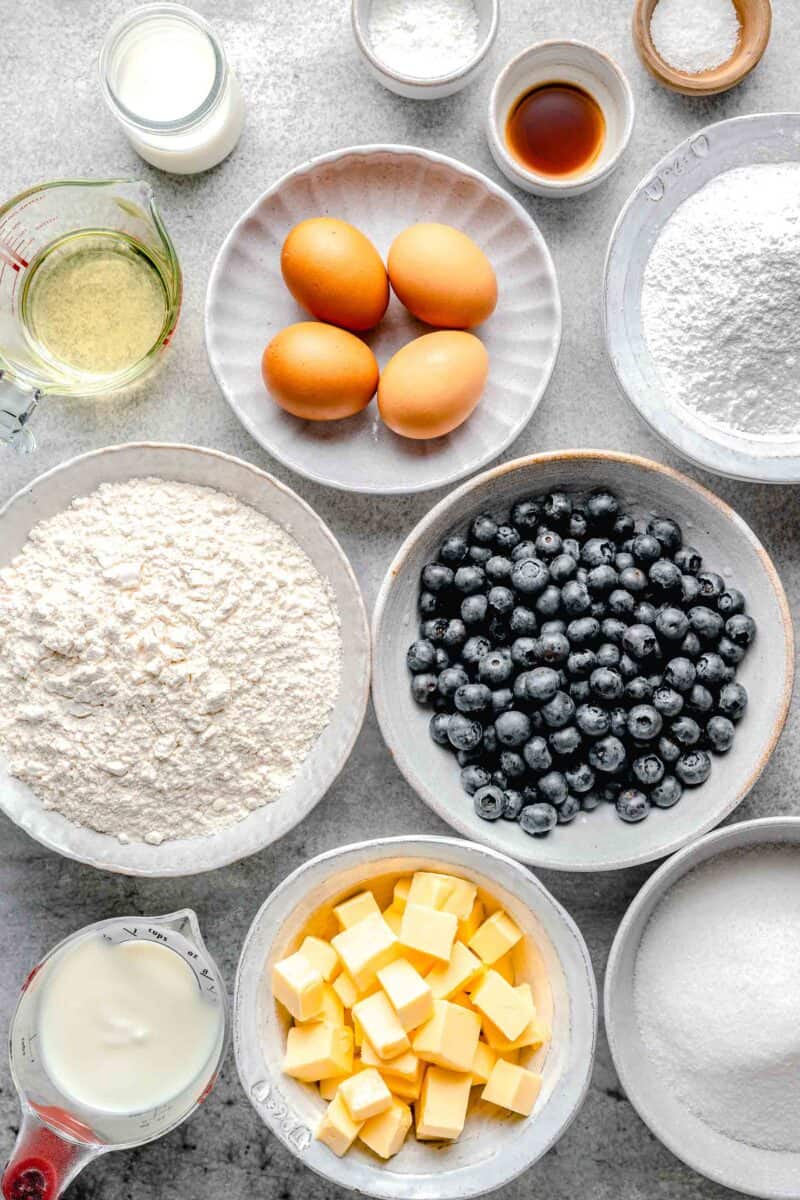 the ingredients for blueberry bundt cake are placed on a white surface