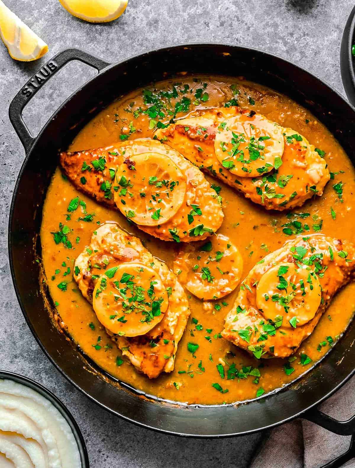 Overhead image of chicken francese in a pan.