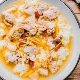 a bowl of chinese chicken soup with rice in a white bowl