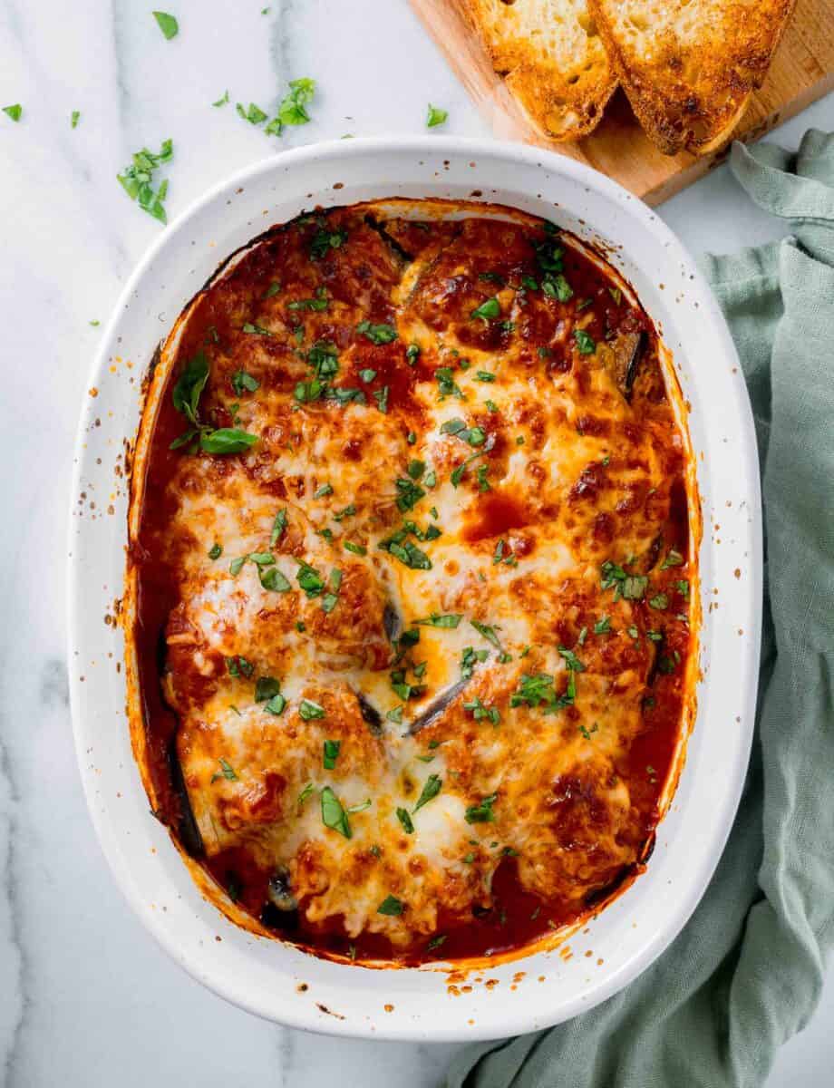 a white casserole dish is filled with baked eggplant rollatini