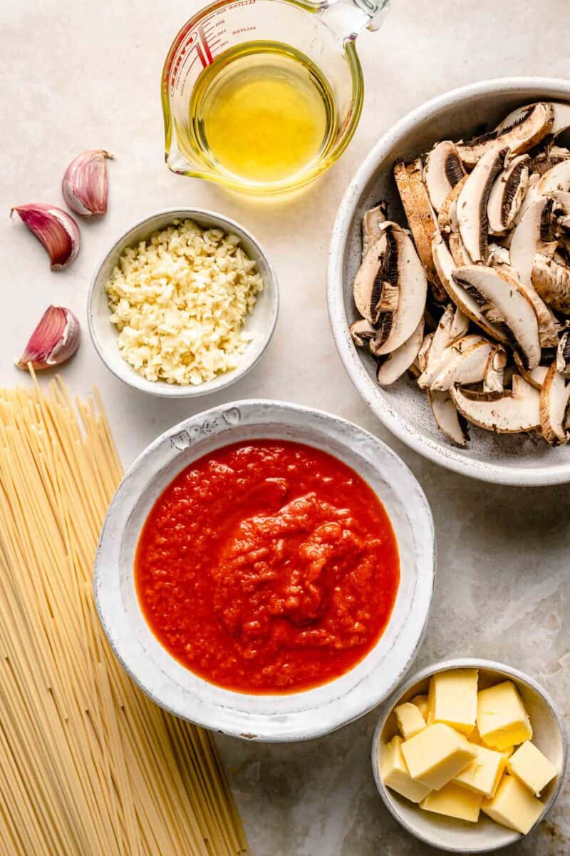the ingredients for garlic mushroom pasta are placed on a countertop