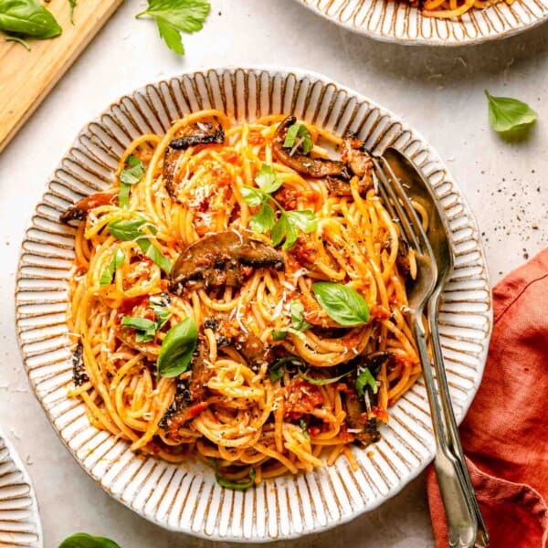 a large serving of pasta is garnished with fresh basil