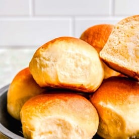 honey butter rolls stacked on a metal plate