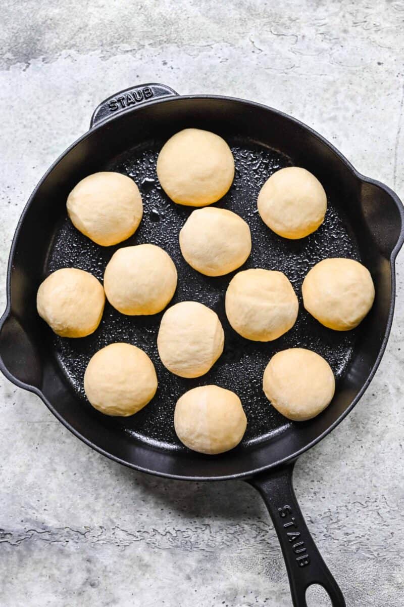 honey butter rolls rolled and placed into a greased cast iron skillet