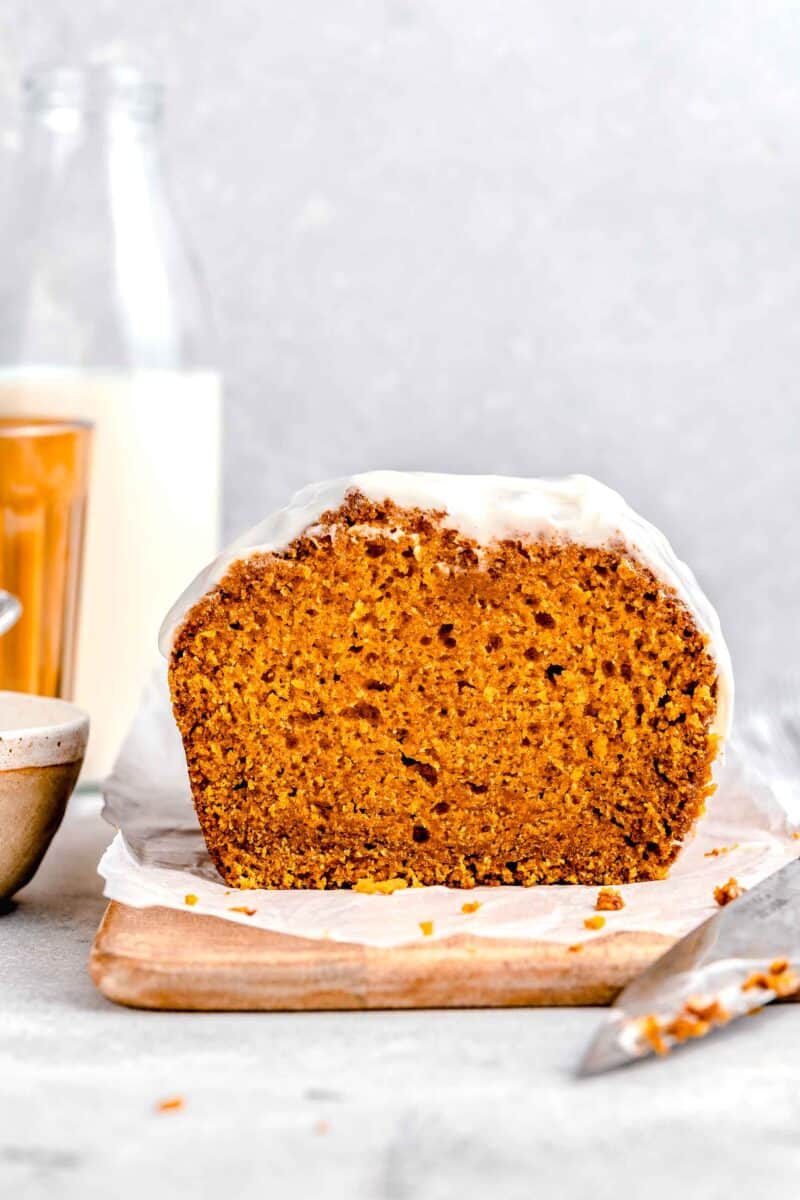 a loaf of frosted pumpkin bread is sliced into