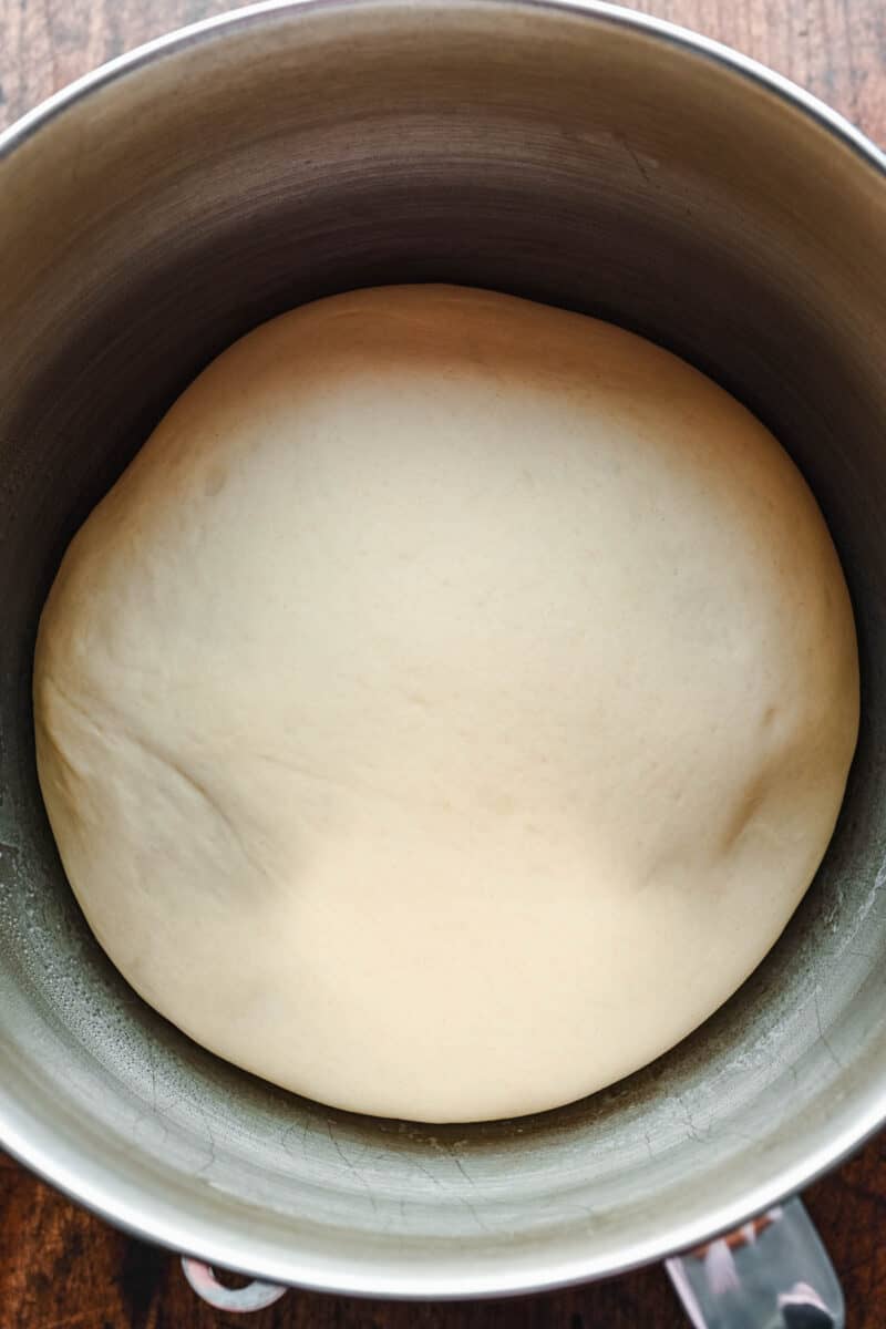 a big ball of dough is rising in a bowl