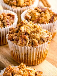pumpkin pecan muffin in a white muffin liner with chopped pecans on top