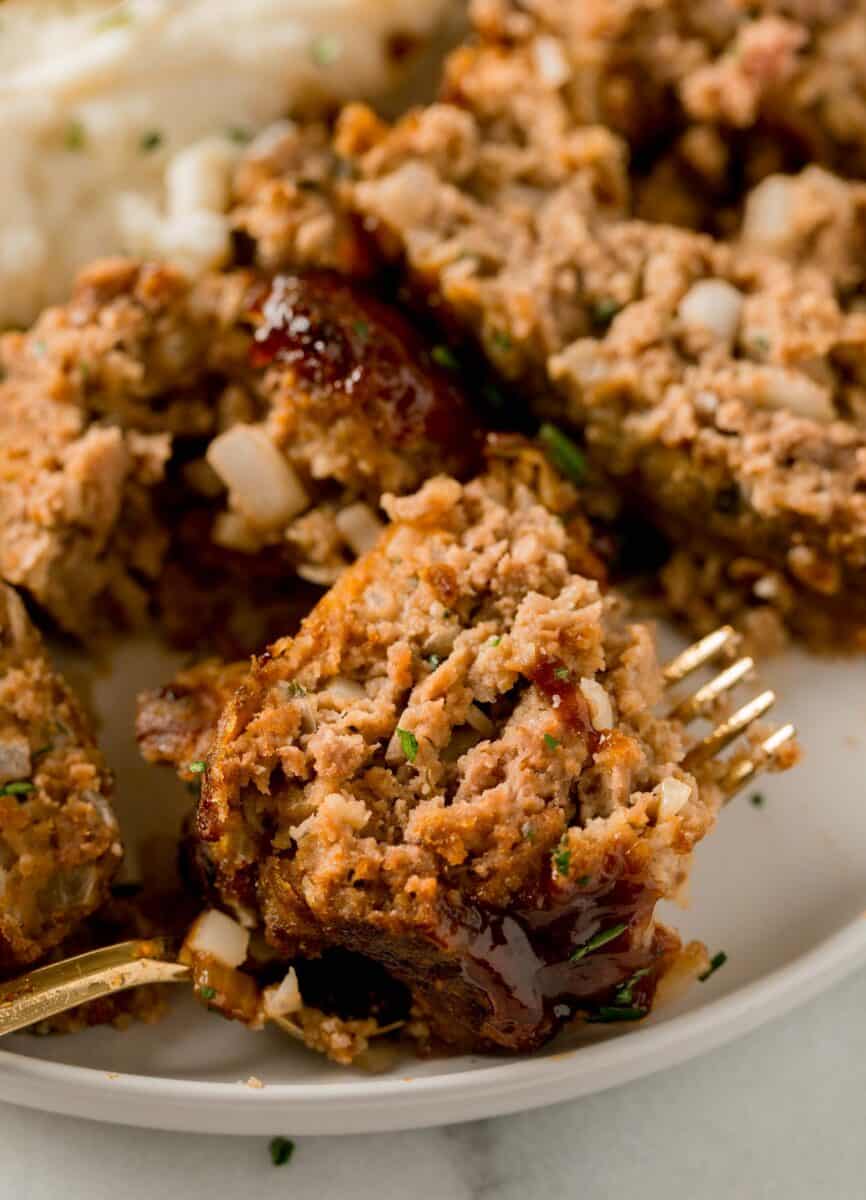 a piece of meatloaf on top of a metal fork