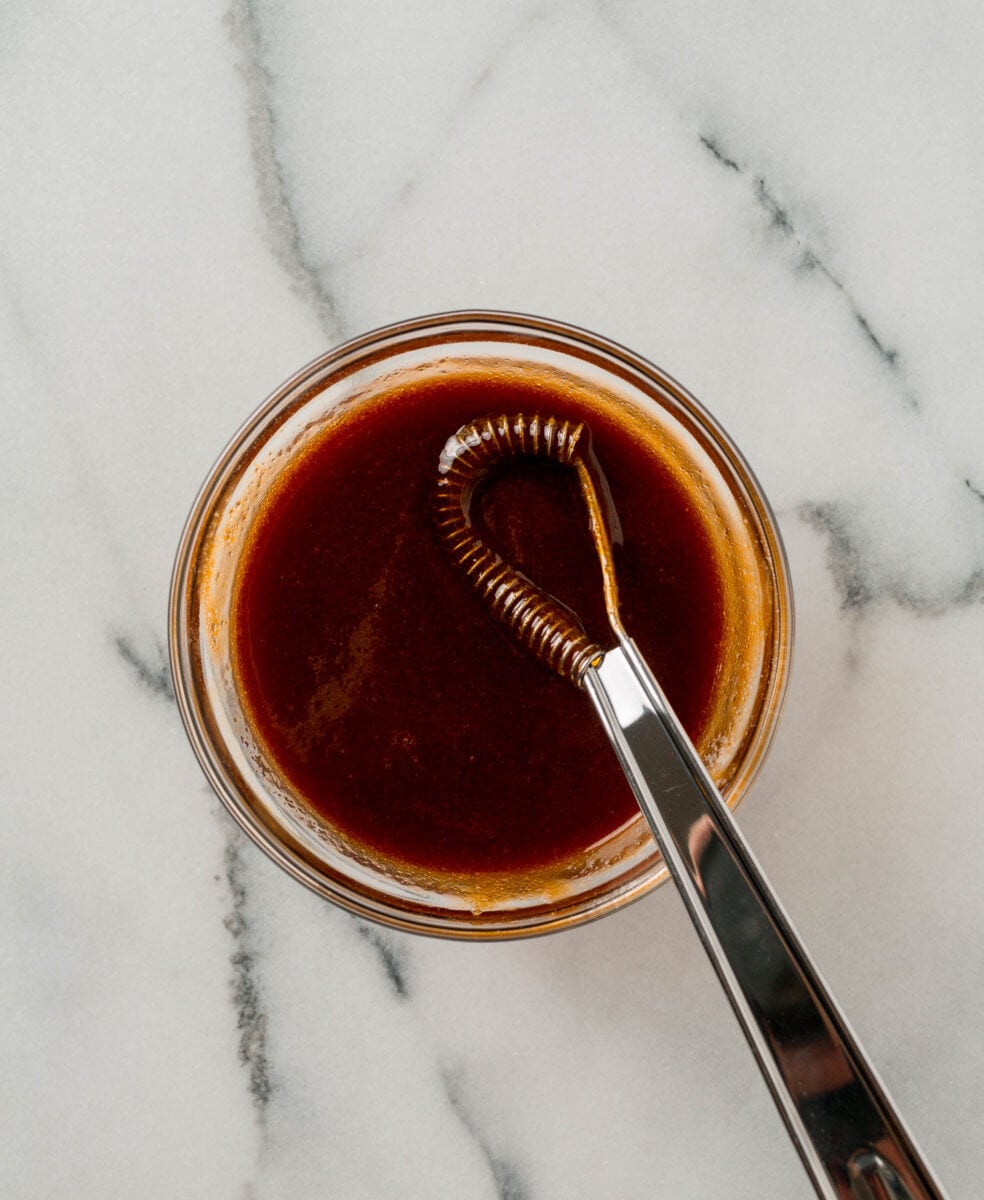 meatloaf glaze whisked together with a metal whisk in a clear bowl