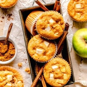 Apple cinnamon muffins in a loaf pan with cinnamon sticks.