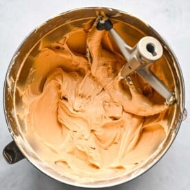 biscoff cream cheese mixture in a metal bowl of a stand mixer with a paddle