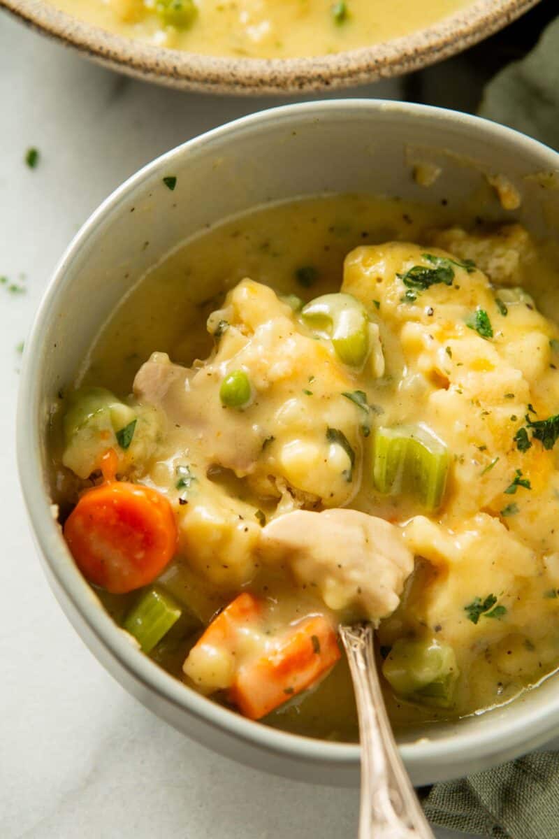 creamy chicken and dumplings mixture in a grey bowl mixed together