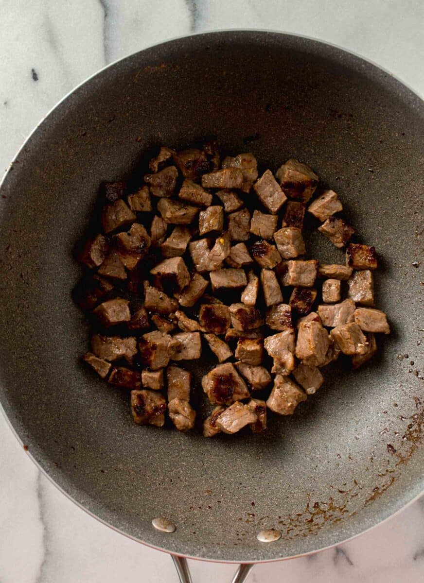 cubed steak seared and browned in a large wok