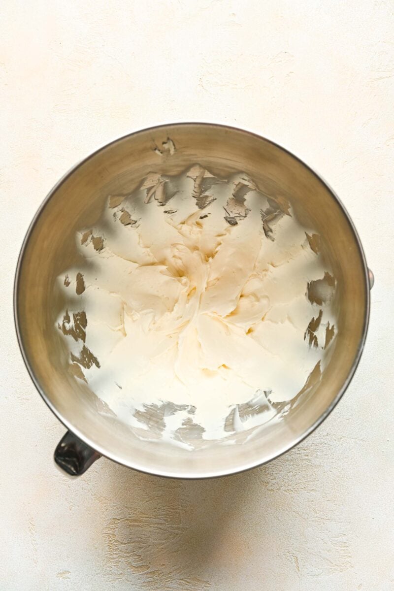 whipped cream cheese in the bowl of a metal stand mixer bowl