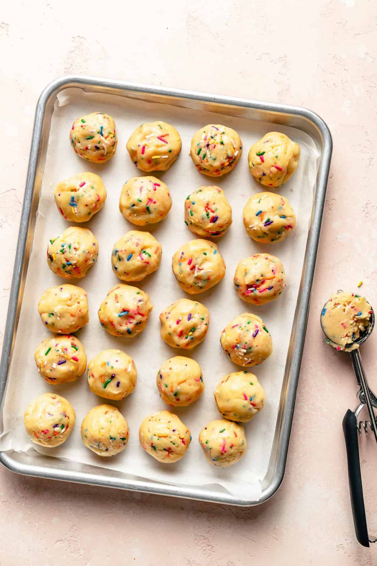 Shaping Funfetti cookie dough into cookies with a cookie scoop.