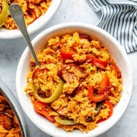 Overhead of smoked sausage and rice in a bowl with a fork.