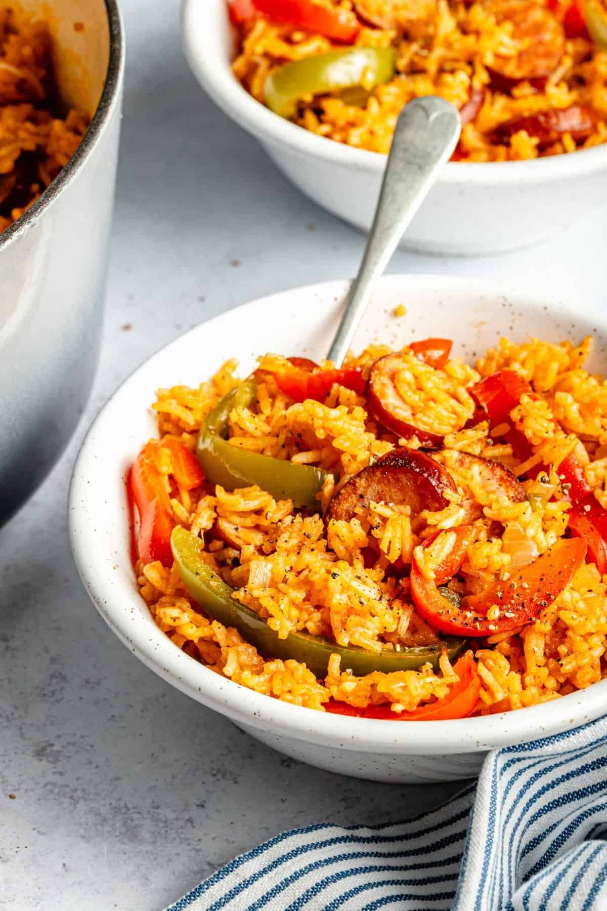 Smoked sausage and rice in a bowl with a fork.