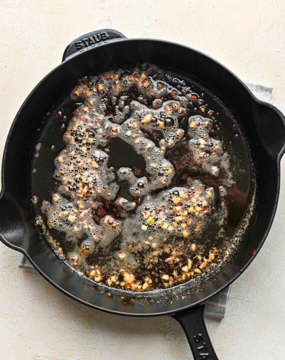 minced garlic cooked in butter in a cast iron skillet