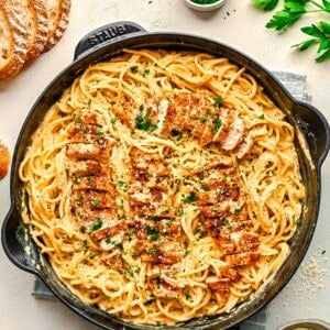 cajun chicken alfredo pasta in cast iron skillet with fresh parsley sprinkled on top