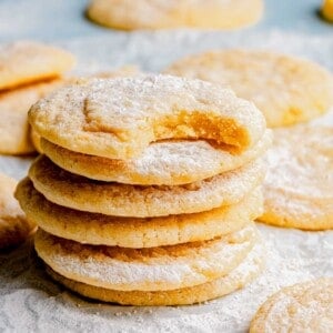 A stack of lemon cookies. The top cookie has a bight taken out of it.