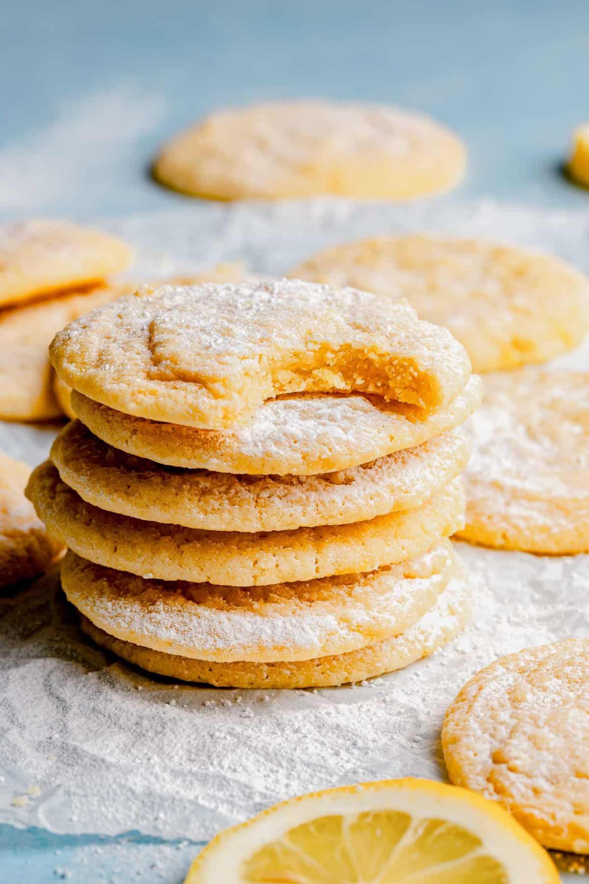 A stack of lemon cookies. The top cookie has a bight taken out of it.