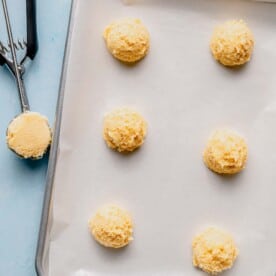 Scooping lemon cookie dough into cookies.