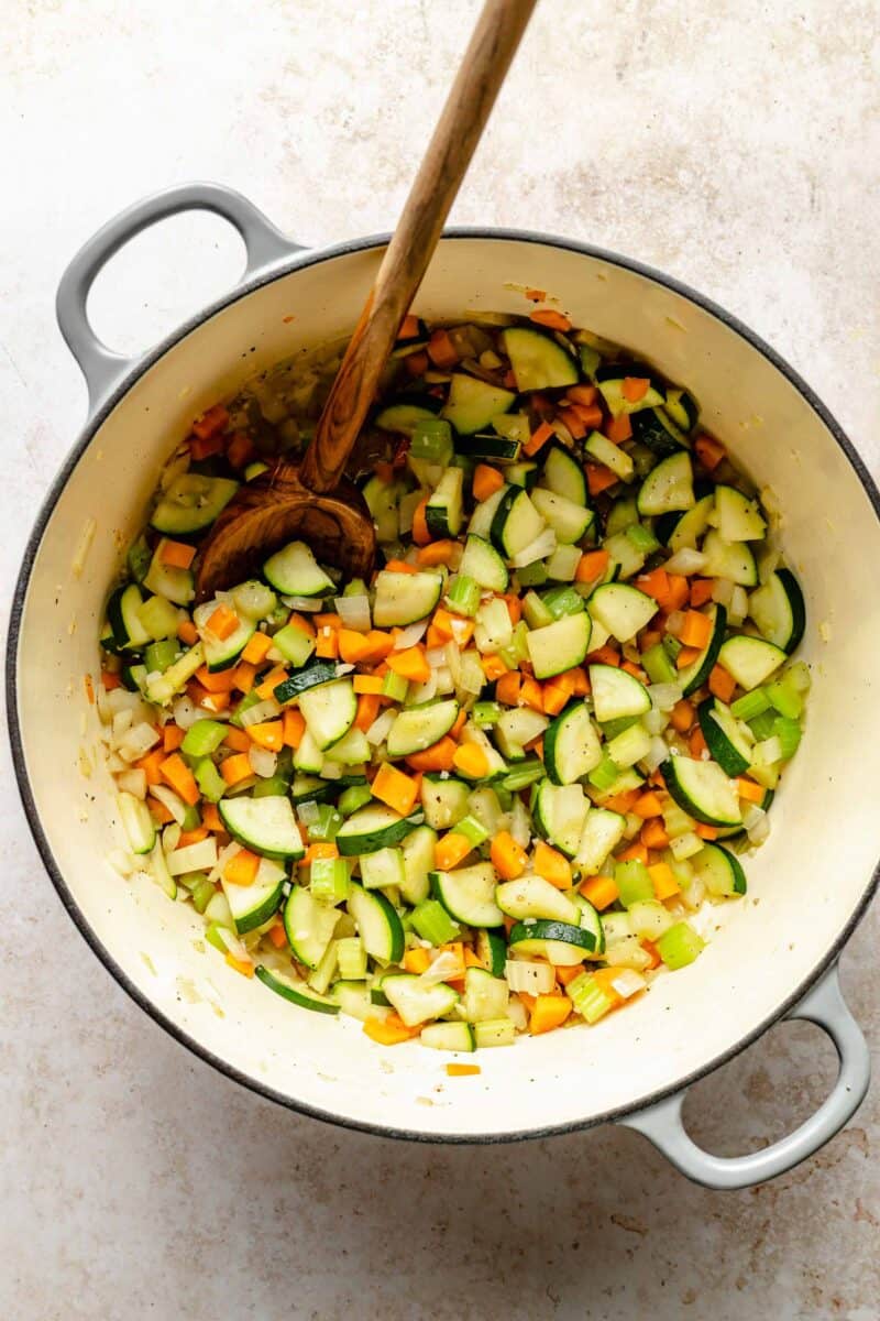 Sauteing onions, carrots, celery, garlic, and zucchini in soup pot.