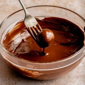 Dipping a peanut butter ball into chocolate with a fork.