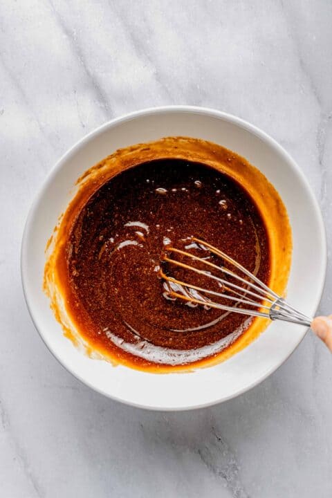 Whisking together wet ingredients for sweet potato bread.