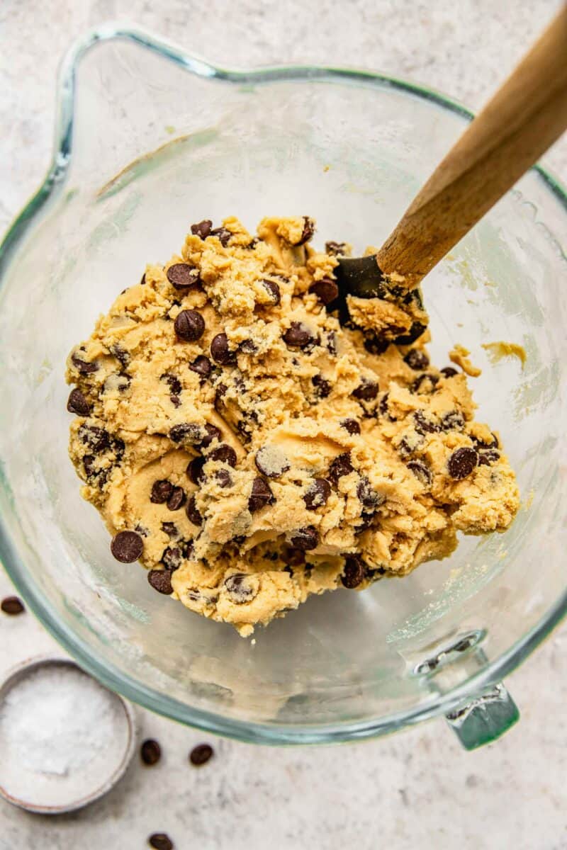 Folding chocolate chips into cookies dough.